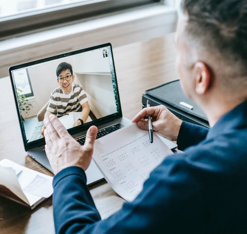 A laptop screen showing a man in a video call.