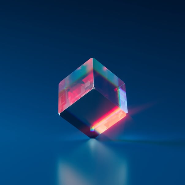 A translucent cube sitting on its vertices, a soft pink light shines through.